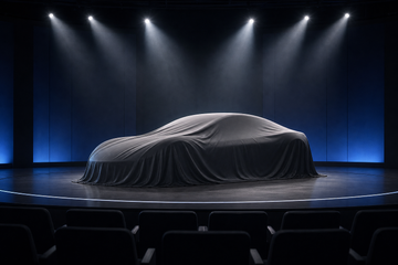 Silhouette of a covered Tesla Roadster under stage lights awaiting reveal