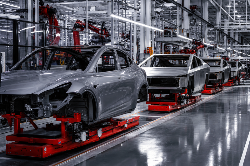 Tesla factory assembly line with Model Y and Cybertruck vehicles