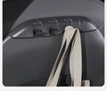 Canvas tote bag hanging from an open TESERY hook on the back of a Tesla front seat.