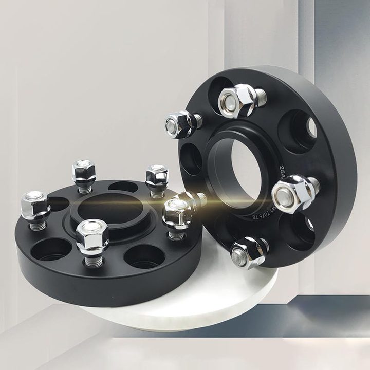Two TESERY forged wheel spacers displayed on a pedestal, showing black bodies, center lips and silver hardware.